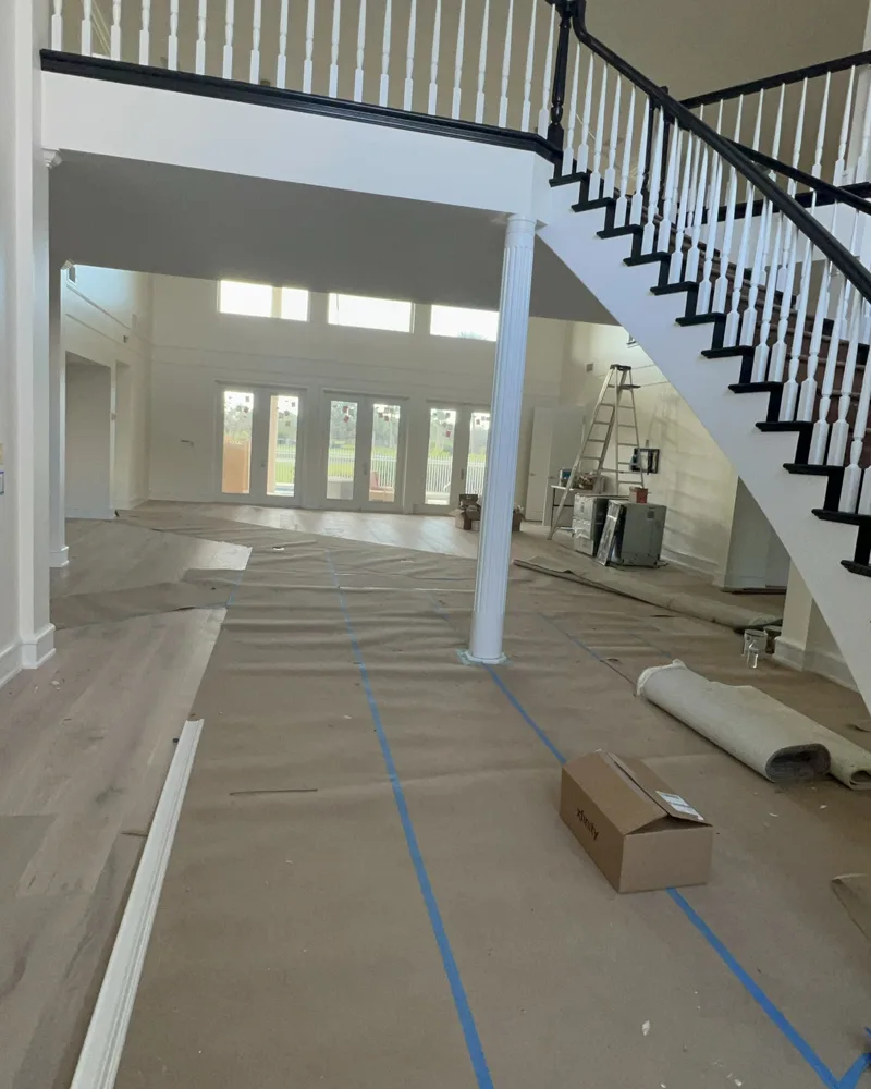 Process: handrails refinished in black, balusters and stair skirt painted white, floors protected