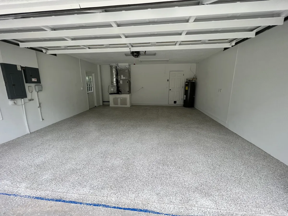 After: the same garage with a seamless gray flake floor coating and freshly painted white walls