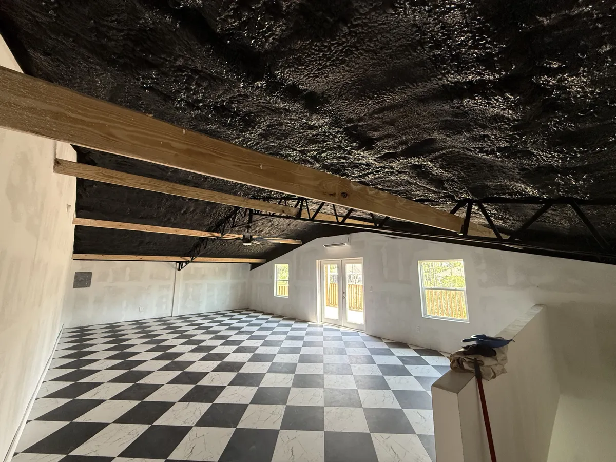 After: the loft with a uniform black open ceiling over the trusses and wood beams