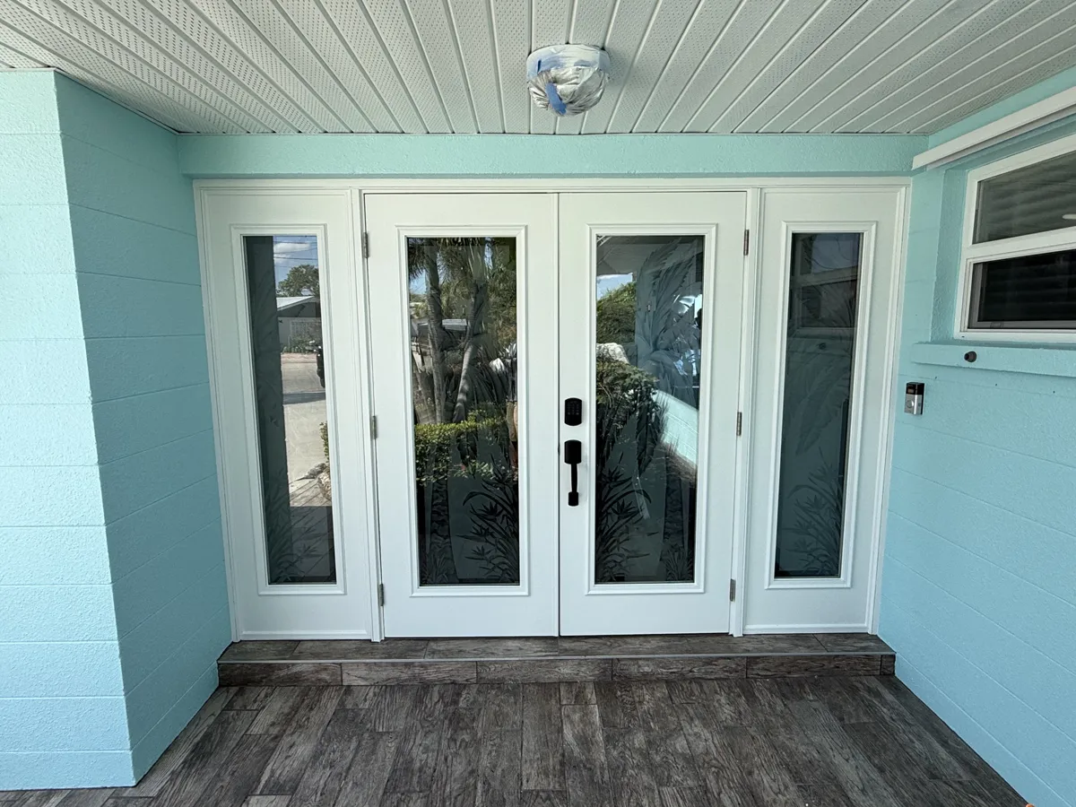 After: finished white double entry doors with sidelites against a turquoise stucco wall