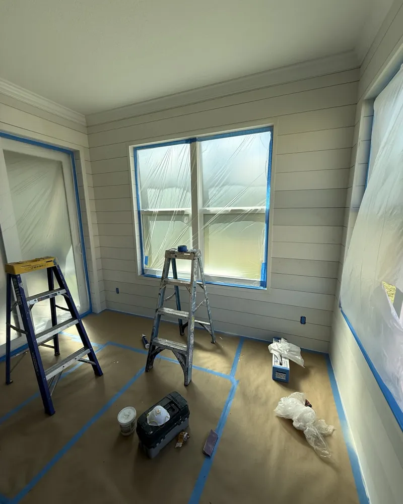 During: new shiplap installed on every wall, windows and doors masked and floor covered for finishing