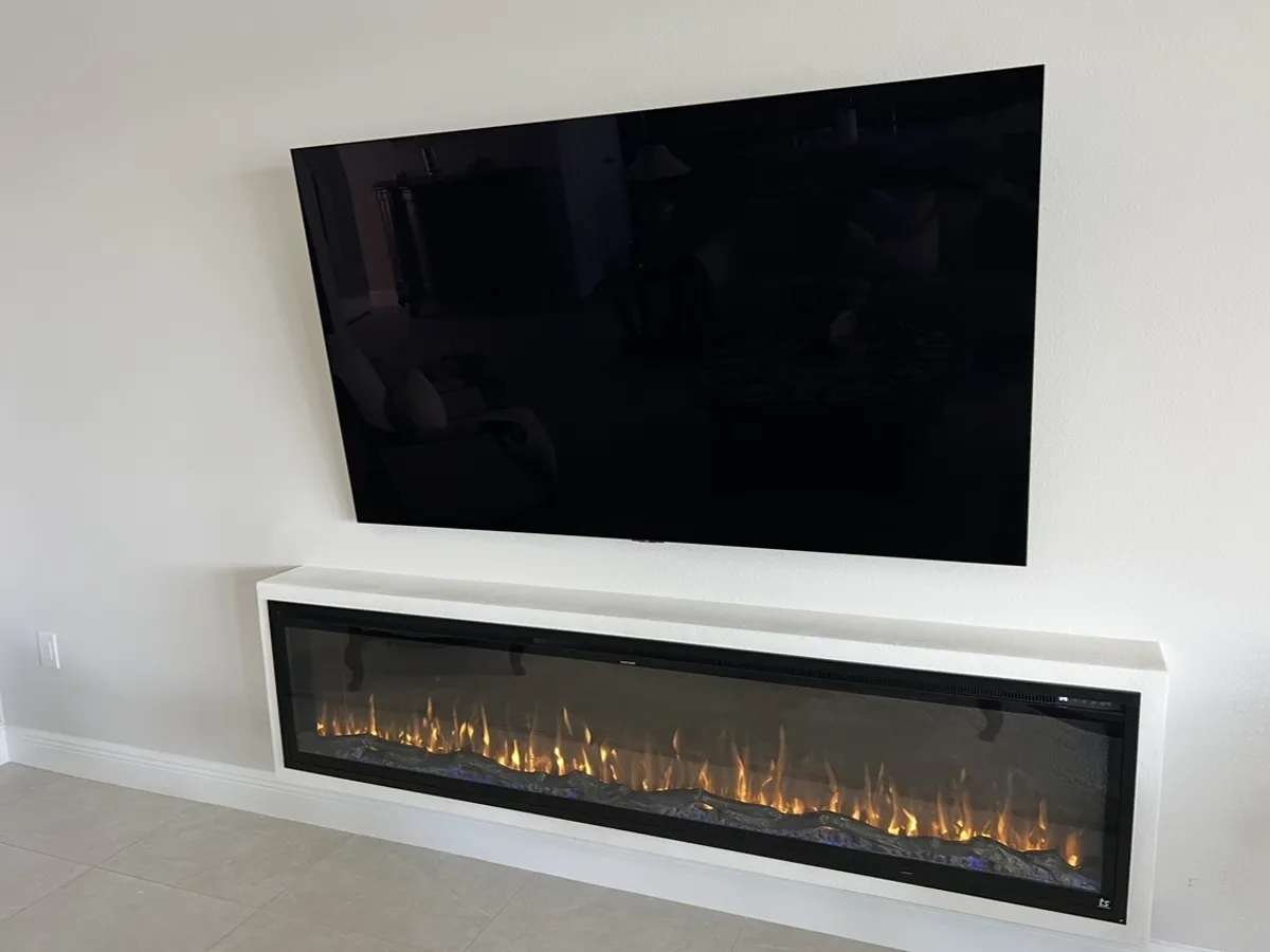 After: finished floating box with a long linear electric fireplace below the TV, textured and painted to match the wall