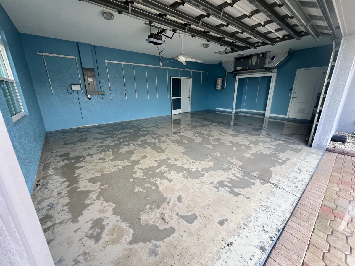 Before: two-car garage with a worn, peeling old floor coating and stained concrete