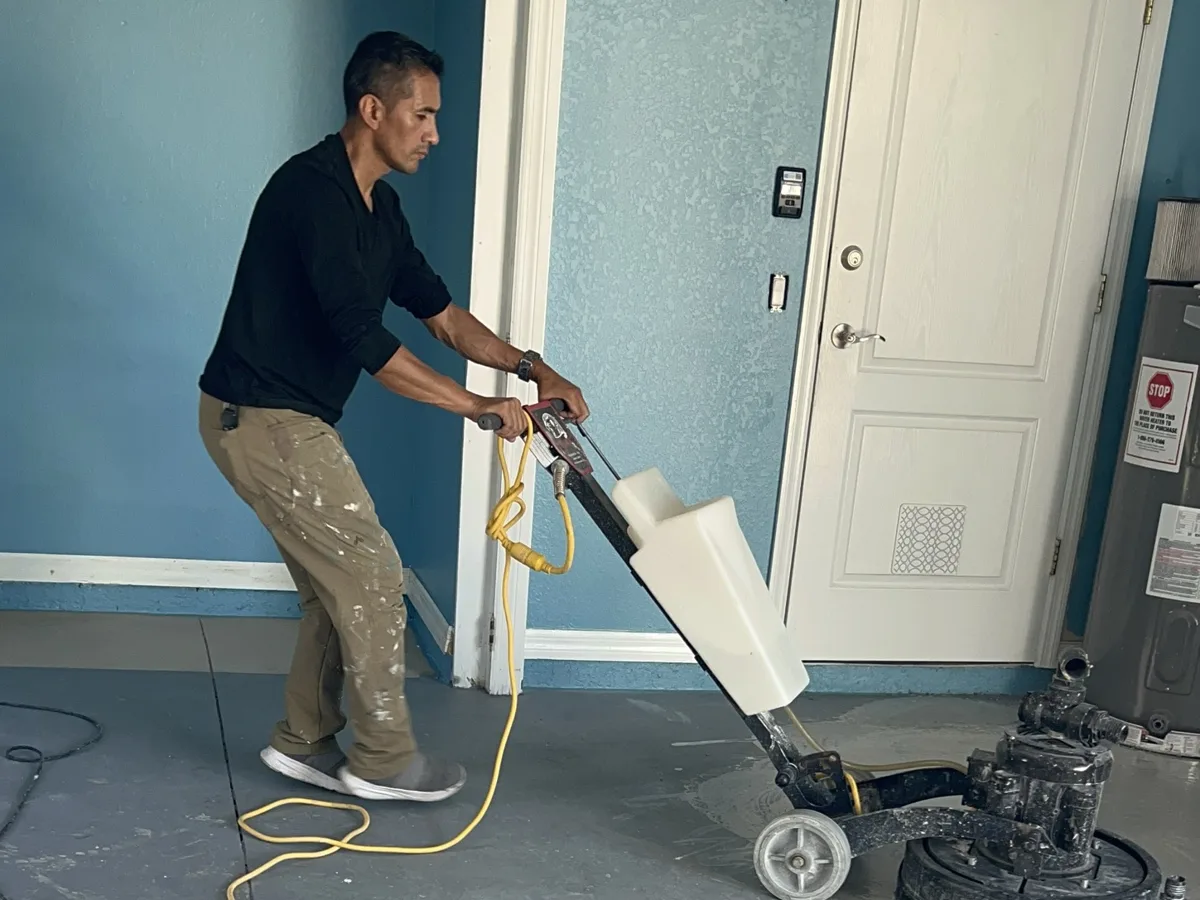 Prep: grinding the old failed coating off the garage slab with a floor grinder