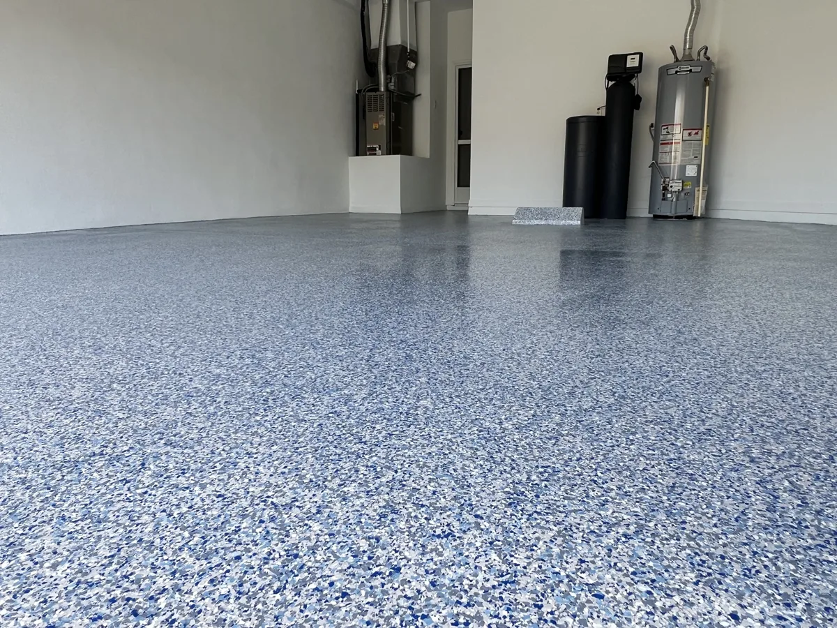 After: the garage with a blue, gray and white full-flake floor coating and freshly painted white walls