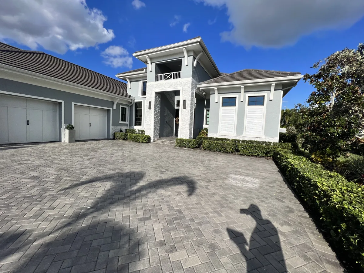 After: the finished exterior in two-tone gray with crisp white trim, brackets and garage doors