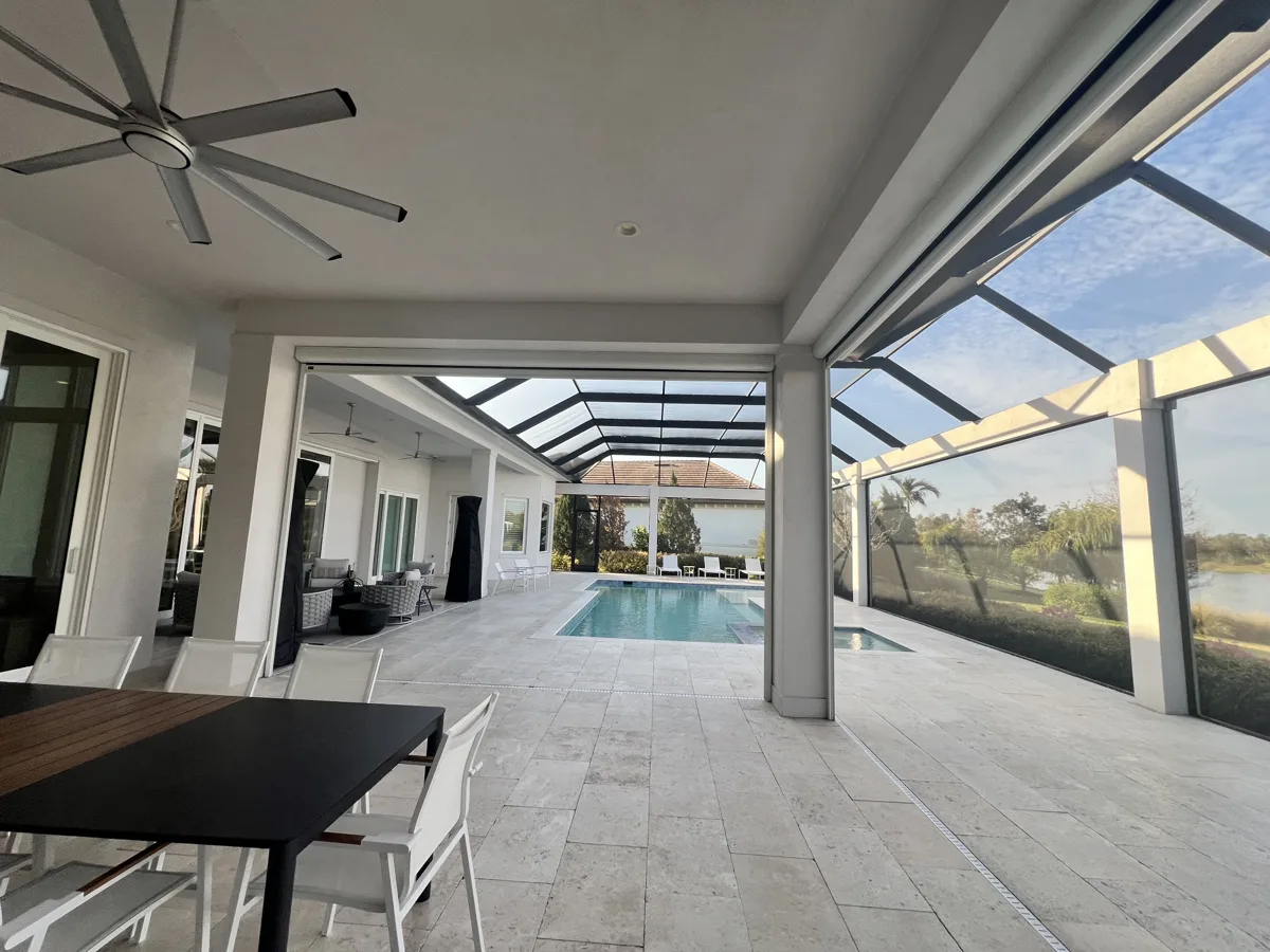 After: covered lanai with smooth white ceiling, beams and columns looking out to the pool and lake