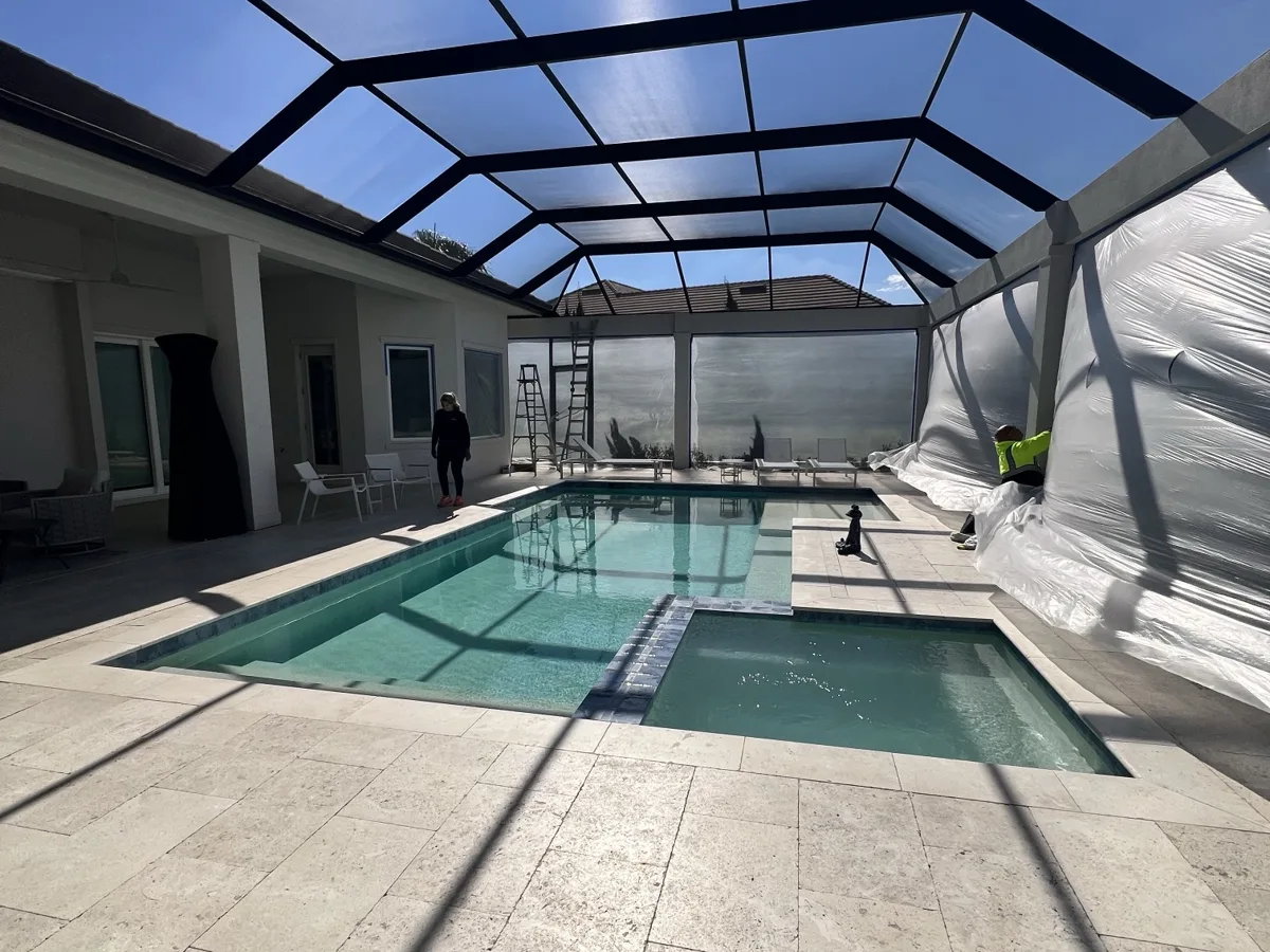 During: pool enclosure screens wrapped in plastic and pool deck protected while the lanai is prepped for painting