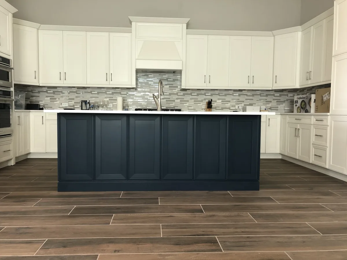 After: kitchen island refinished in a deep navy blue between white shaker cabinets