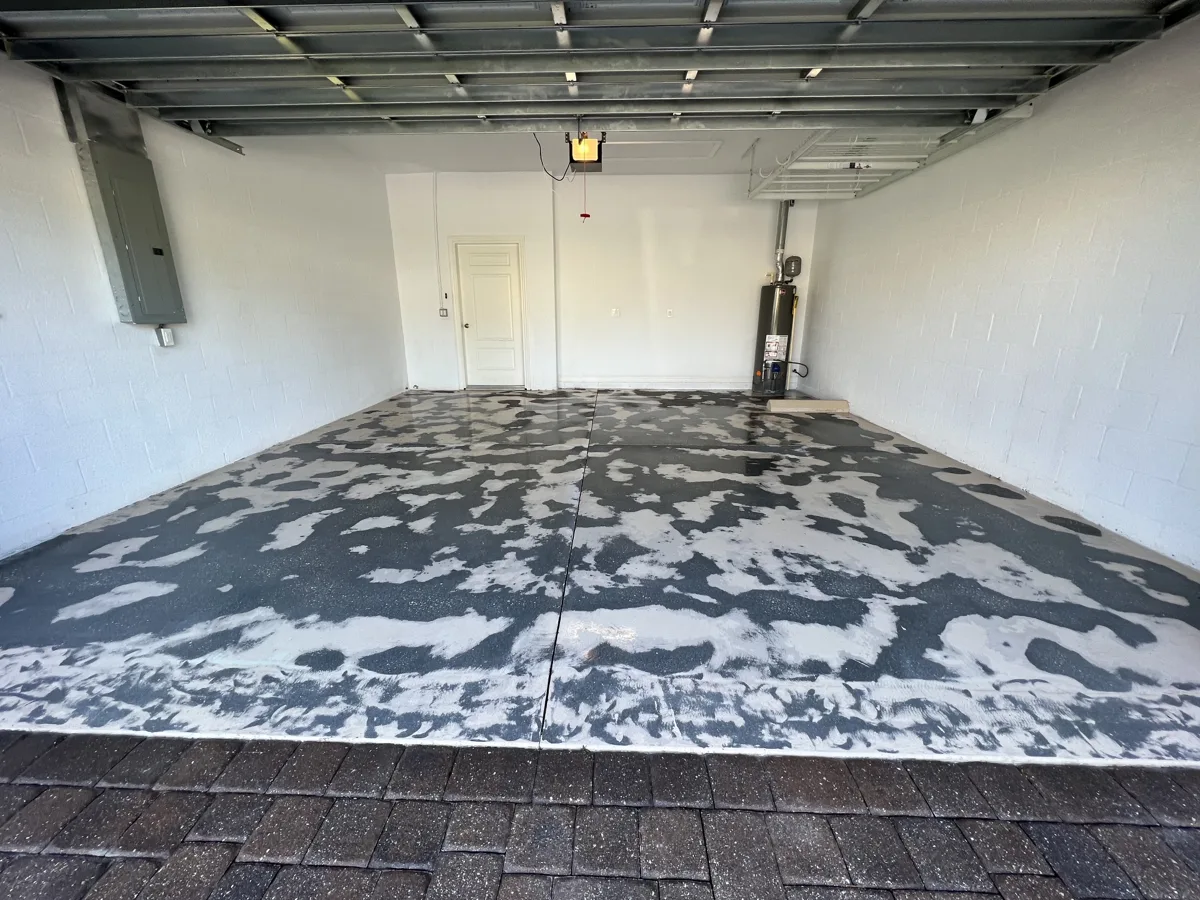 Grinding: old failed garage coating ground off in patches down to bare concrete