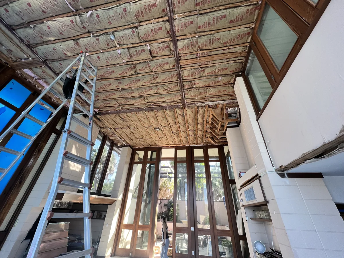 Before: high vaulted ceiling opened to the joists and insulation in a waterfront home