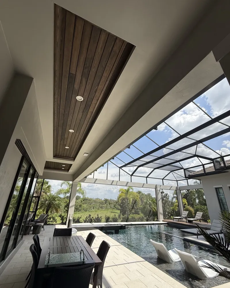 Sealed wood ceiling inset over the pool lanai dining area under a screened enclosure