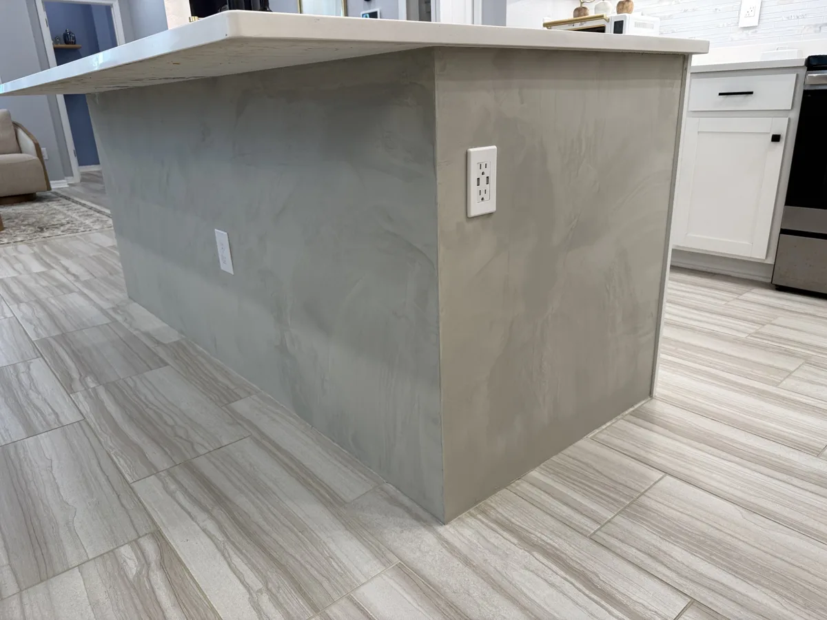 After: kitchen island finished in soft gray Venetian plaster with a hand-troweled, marble-like movement