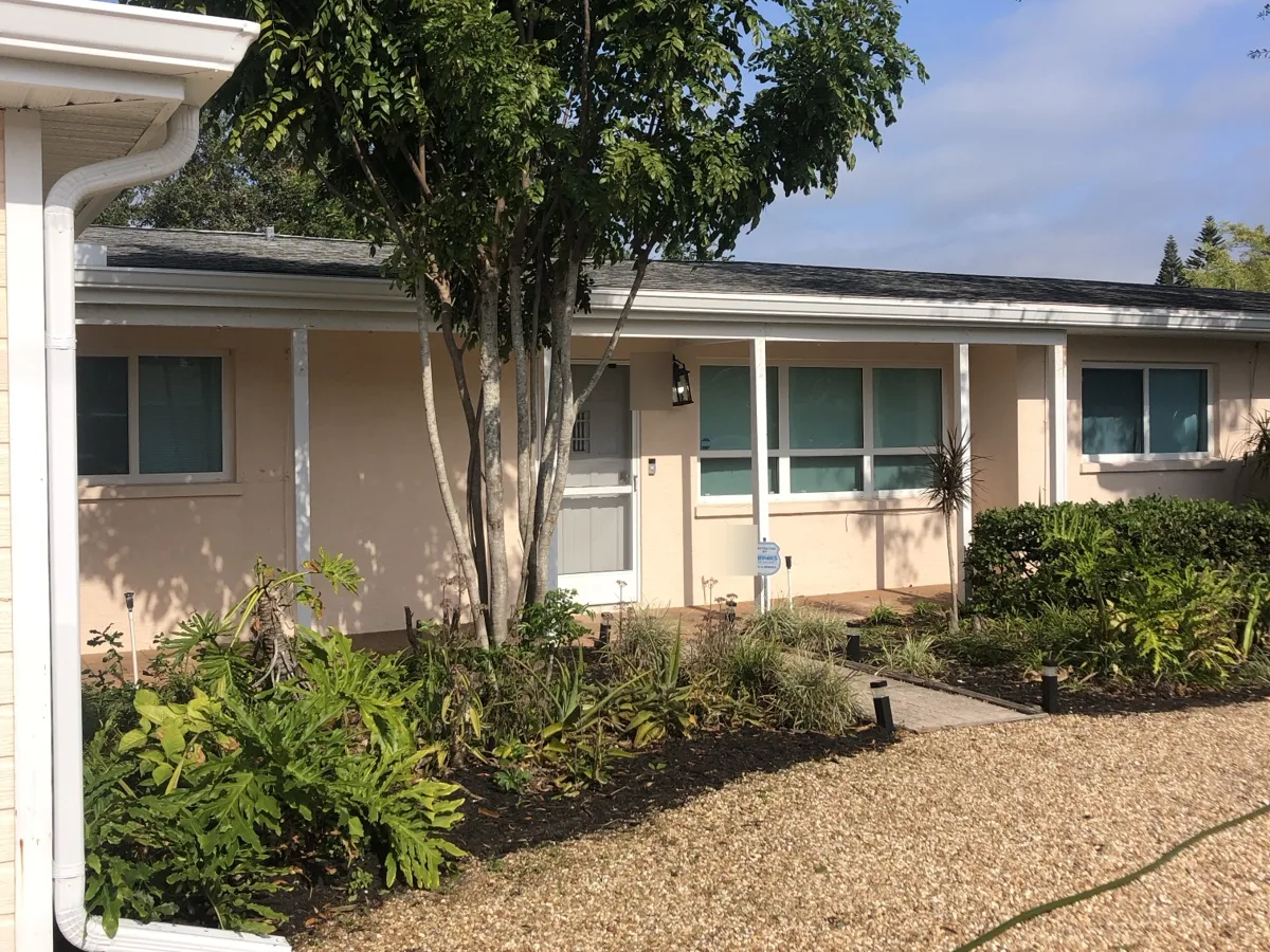 Before: single-story ranch home in a faded beige with white trim