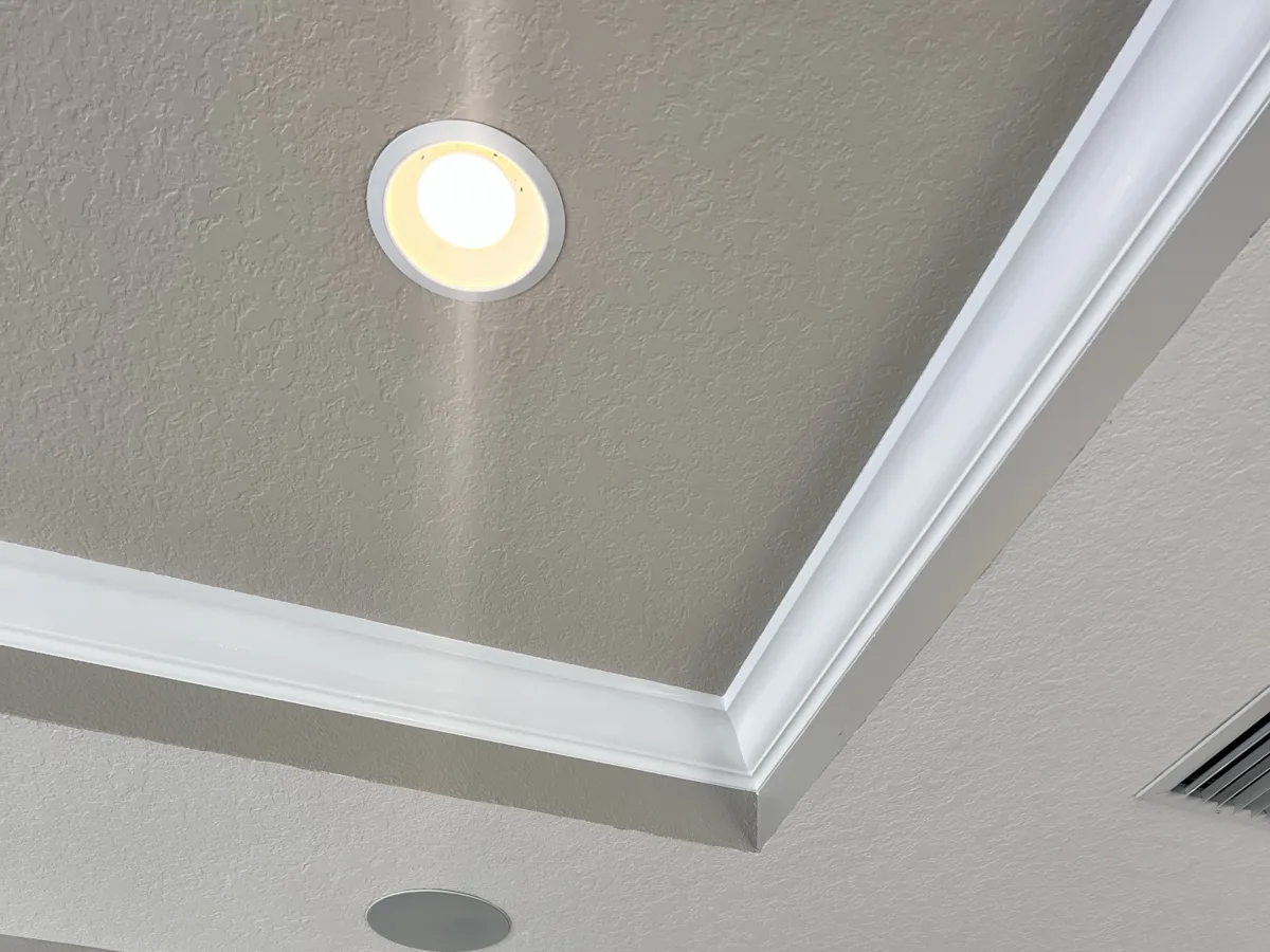 After: tray ceiling painted in a contrasting color with crisp white crown molding lines