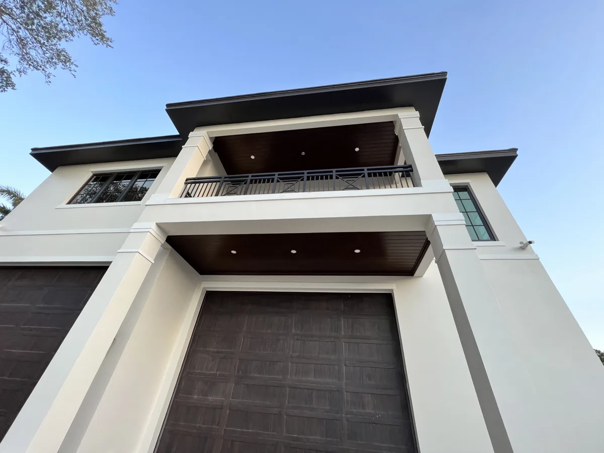After: two-story porch and balcony ceilings finished in dark wood-grain VersaTex PVC with recessed lights