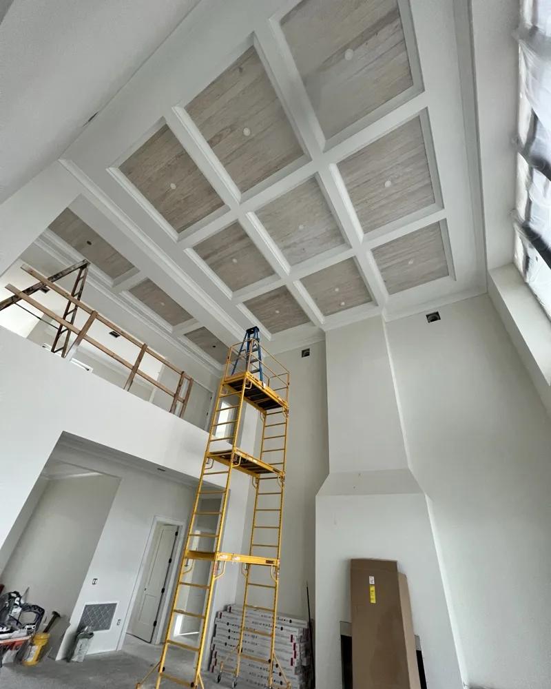 After: each coffered bay filled with light-toned wood tongue-and-groove planks with recessed lights