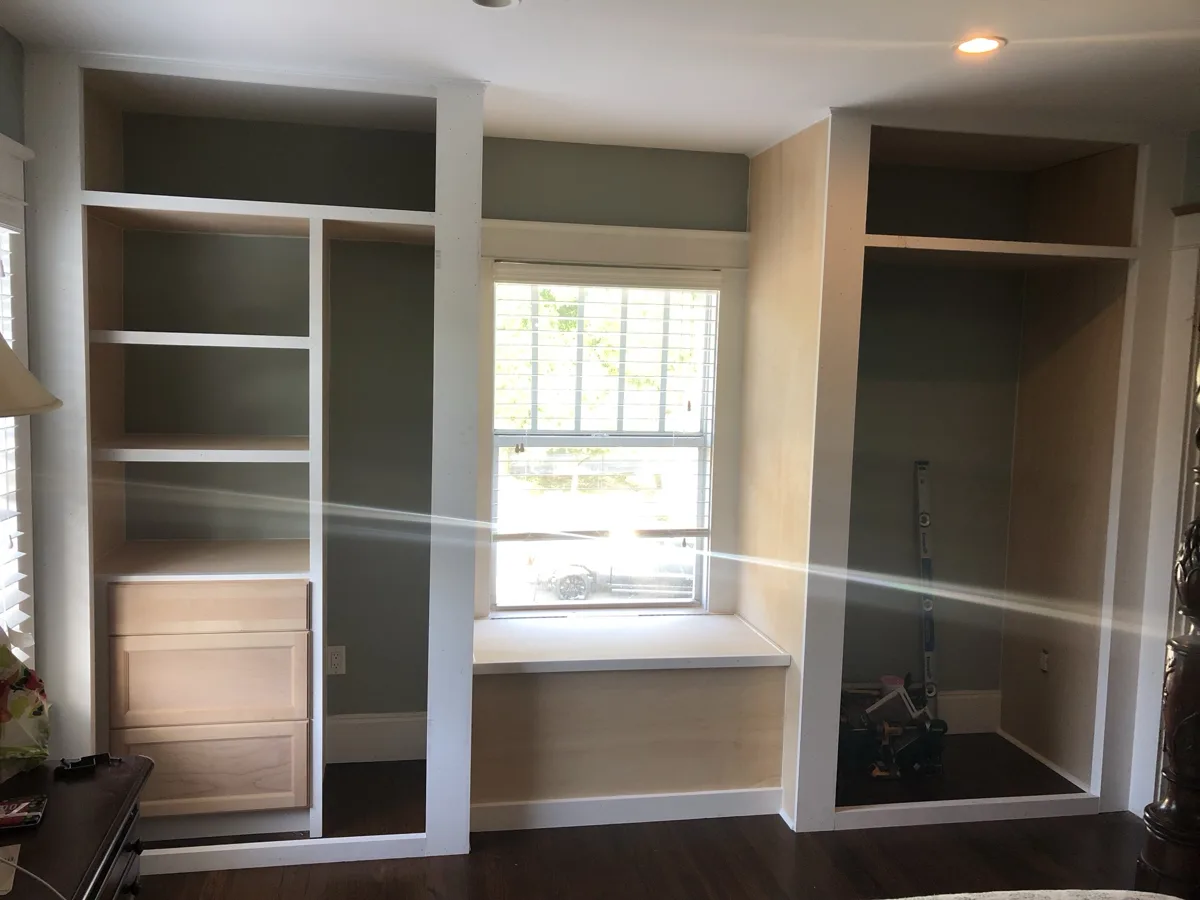 Process: custom built-in closet frames, shelves, drawers and a window seat built from scratch around a bedroom window