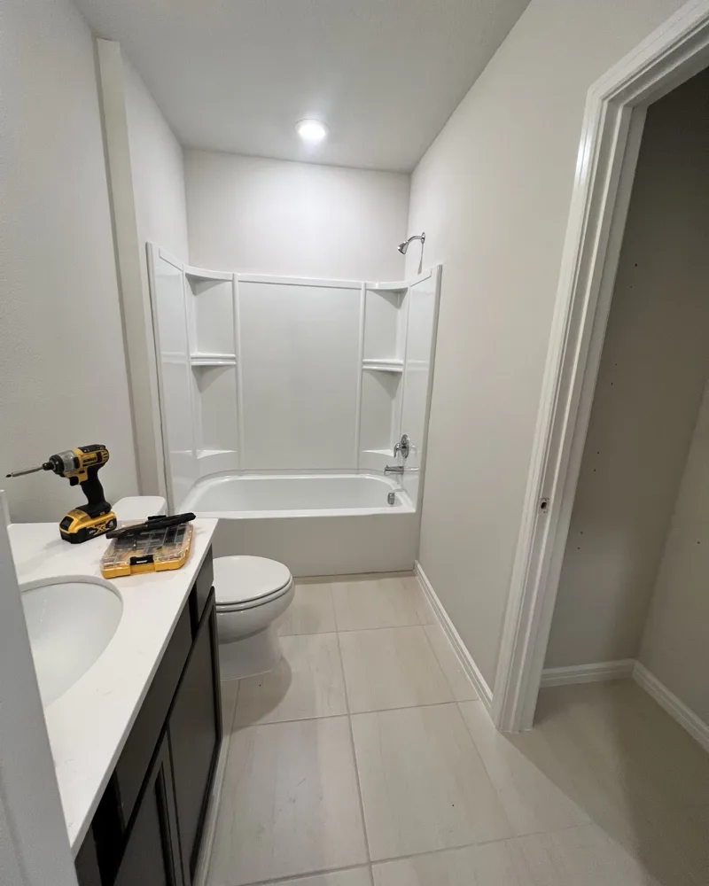 Before: builder-grade bathroom with a fiberglass tub-shower insert and plain tile floor