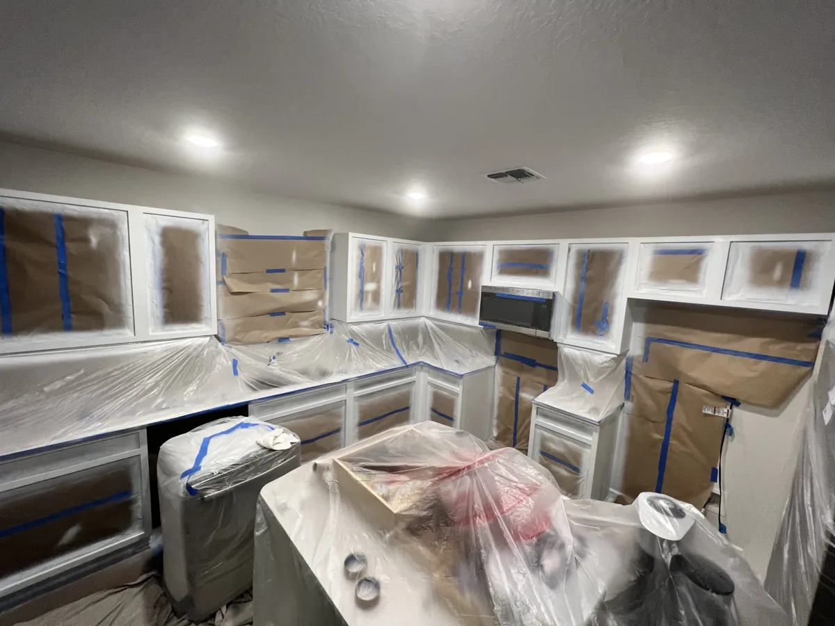 Process: cabinet boxes sprayed white with countertops, appliances and walls fully masked